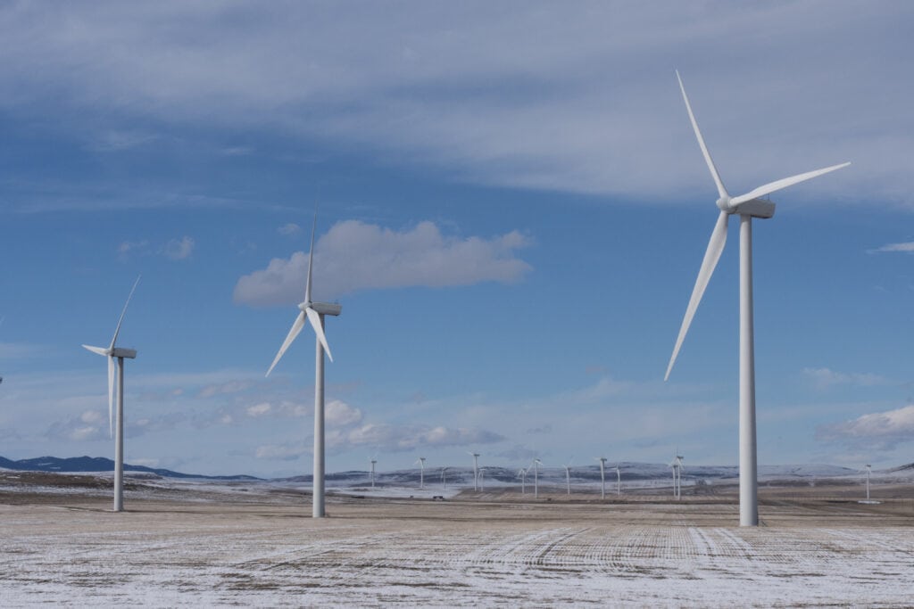 Wind turbines in a snowy field on a sunny day